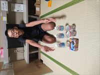 購入した品物の前でポーズをとる様子